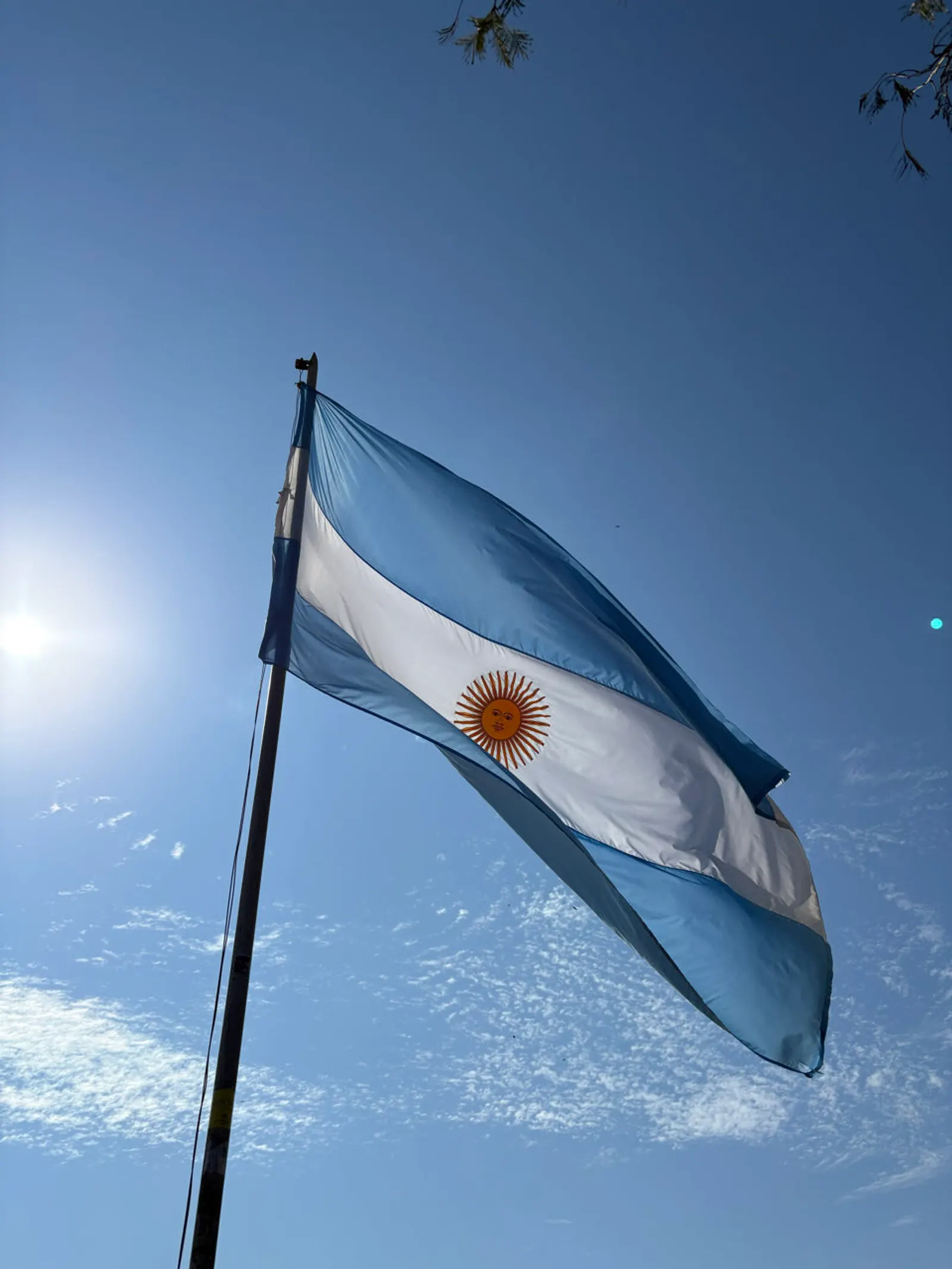 Argentijnse vlag wappert tegen een strakblauwe lucht bij Iguazú
