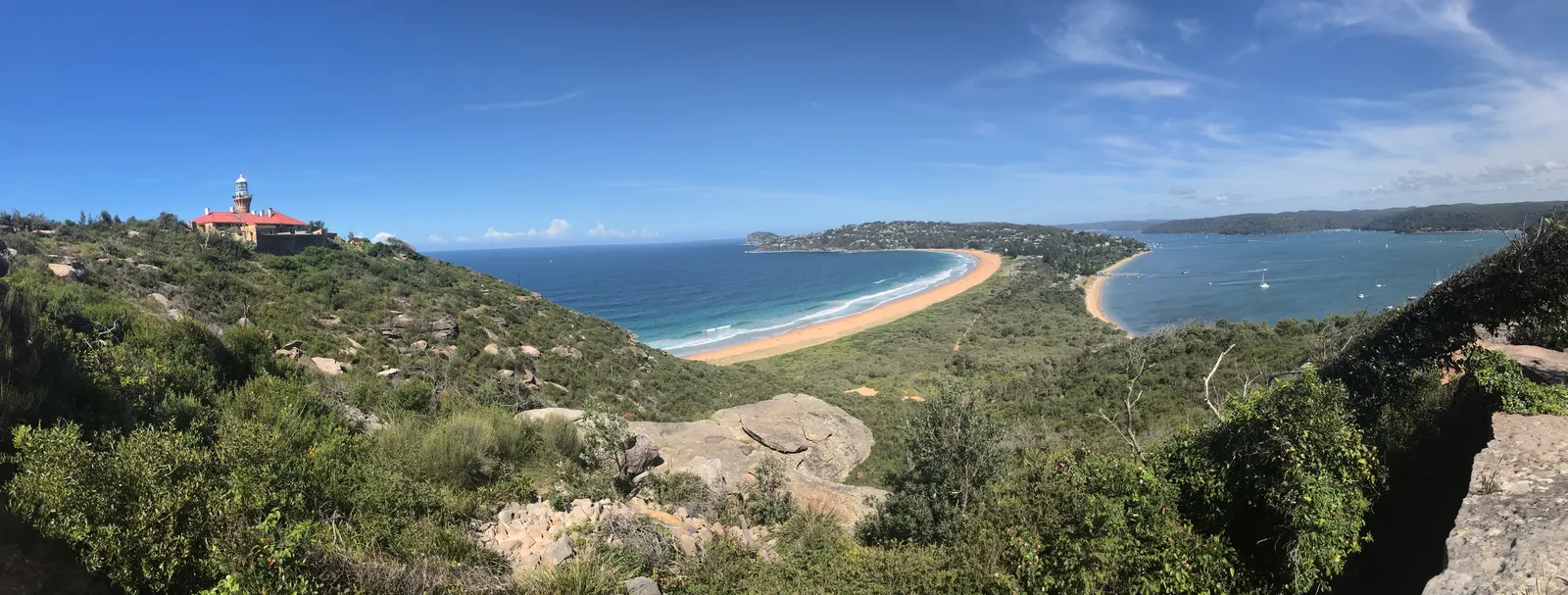 Uitzicht op de gebogen baai van Palm Beach vanaf Barrenjoey