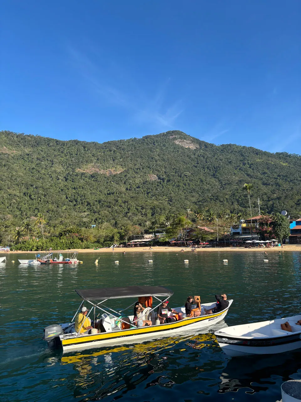 Baai met bootjes en groene bergen op Ilha Grande