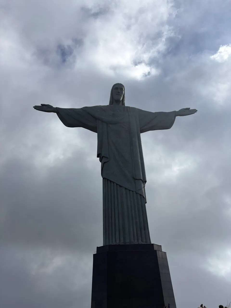 De Cristo Redentor met gespreide armen tegen een bewolkte hemel boven Rio de Janeiro