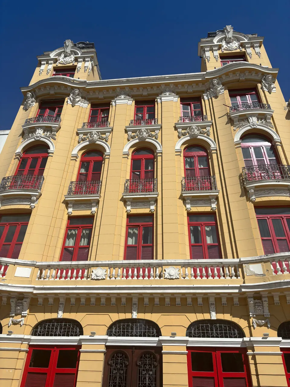 Een geel koloniaal gebouw met rode balkons in het centrum van Rio de Janeiro