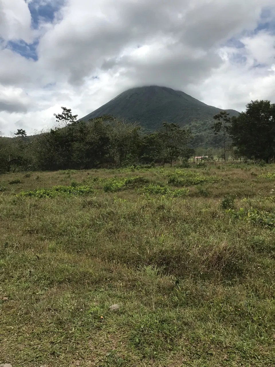 De perfecte kegel van de Arenal-vulkaan onder een bewolkte hemel in Costa Rica