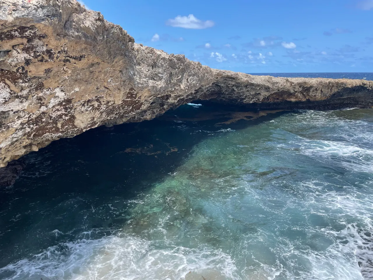 Natuurlijke opening in de rotsen met turquoise water aan de noordkust van Curaçao