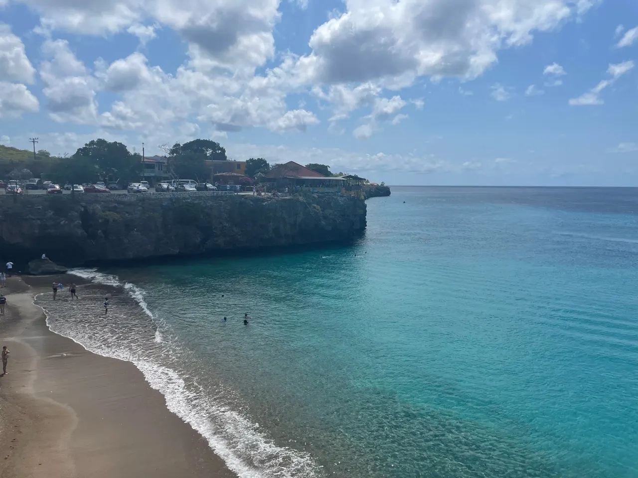 Strandje in een baai met turquoise water en rotsen bij Westpunt op Curaçao