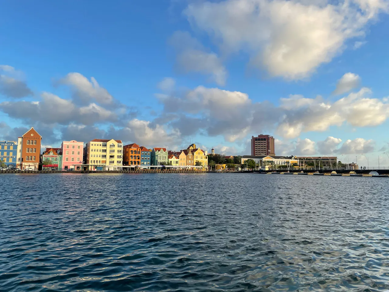 De kleurrijke pastelhuizen van de Handelskade in Willemstad gezien vanaf het water