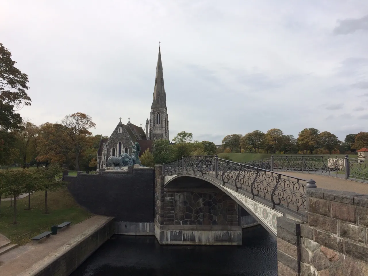 Een gracht met een brug en een kerktoren op de achtergrond in Kopenhagen