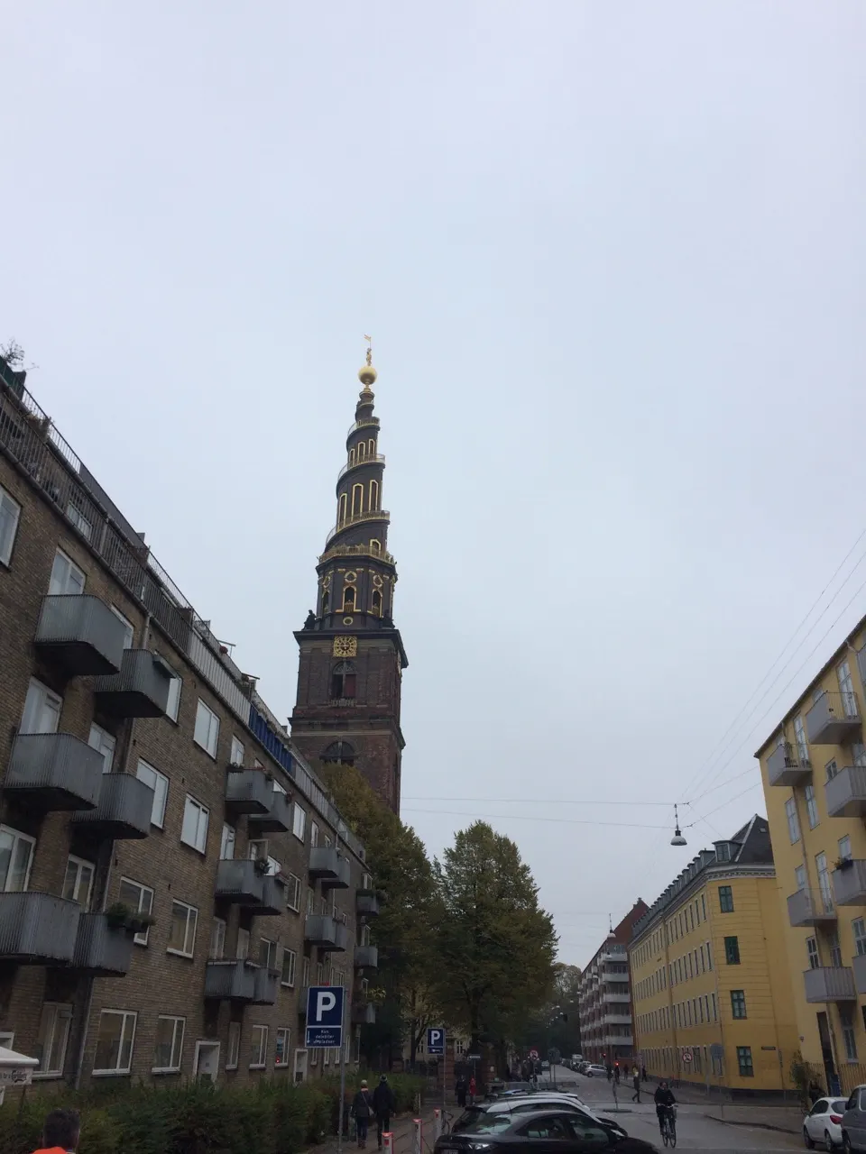 Een straat in Kopenhagen met een kerktoren met spits op de achtergrond