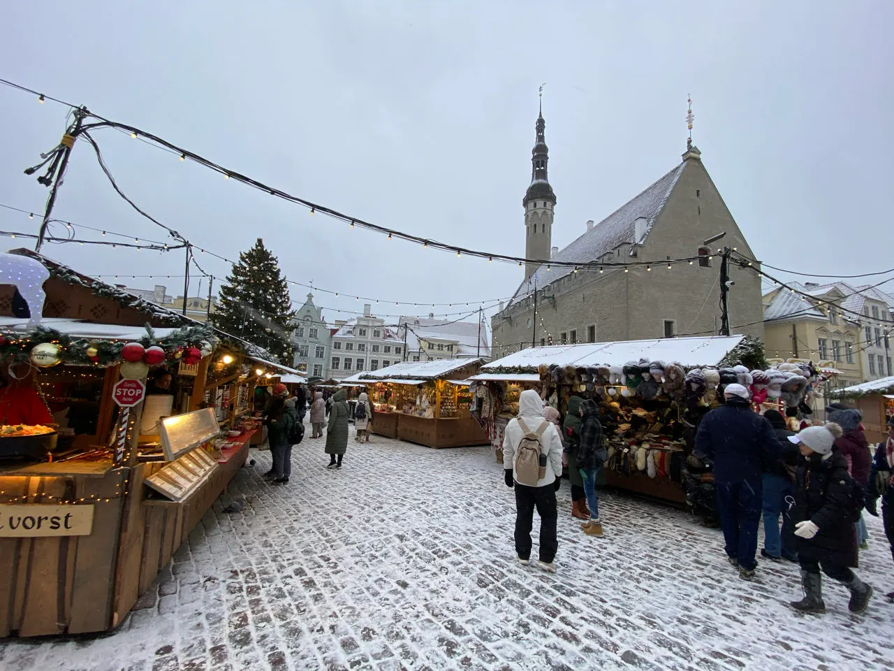 Besneeuwd marktplein met kraampjes tijdens de kerstmarkt van Tallinn