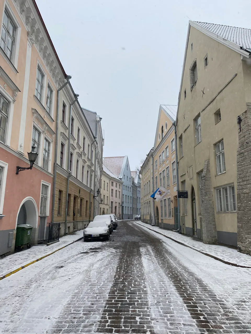 Pastelkleurige huizen langs een besneeuwde straat in de oude stad van Tallinn
