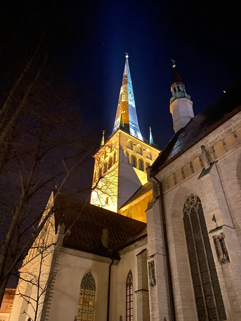 De verlichte spits van de Sint-Olafkerk in Tallinn in de avond