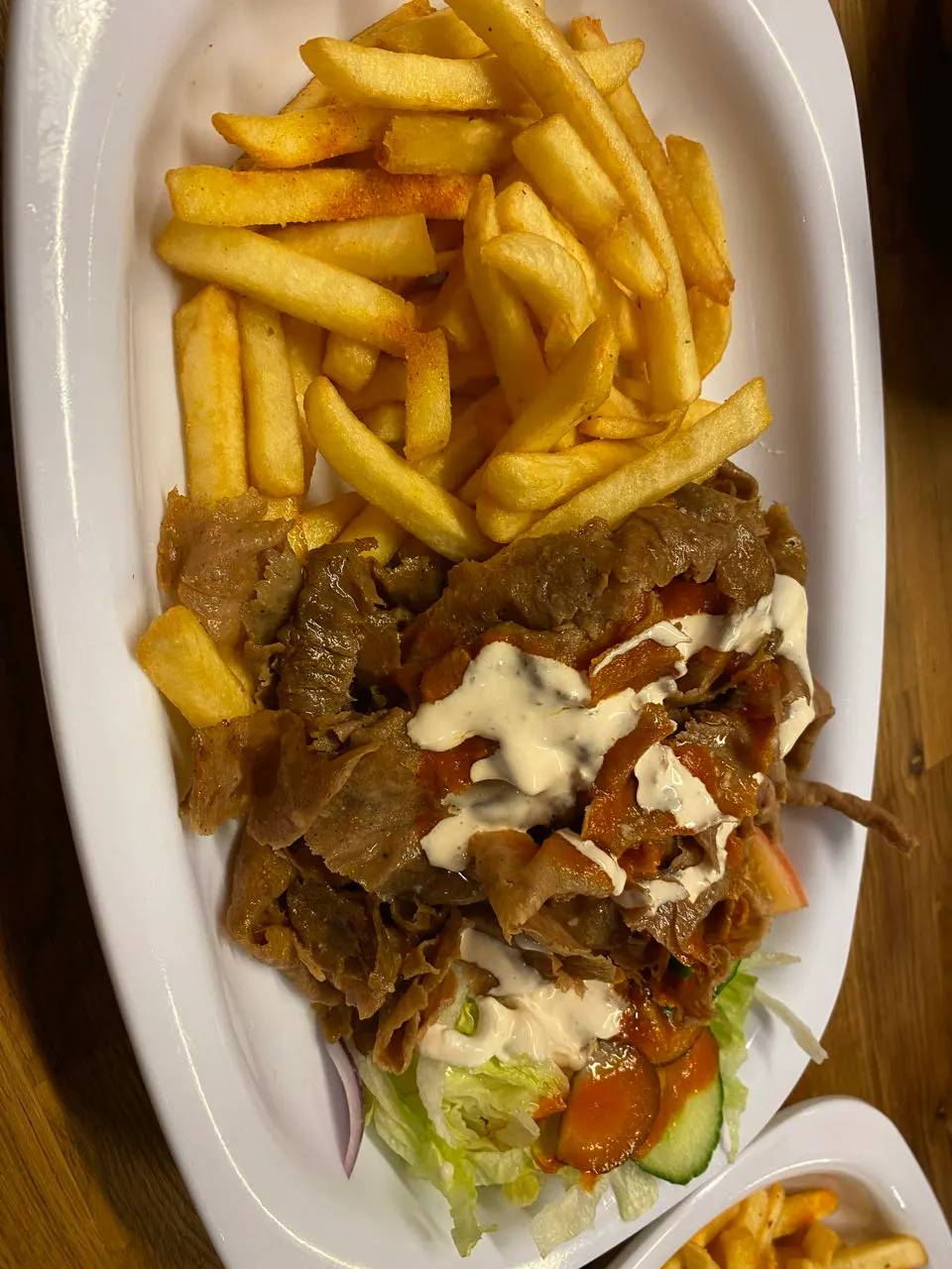 Een kapsalon met rendiervlees, friet en saus op een bord