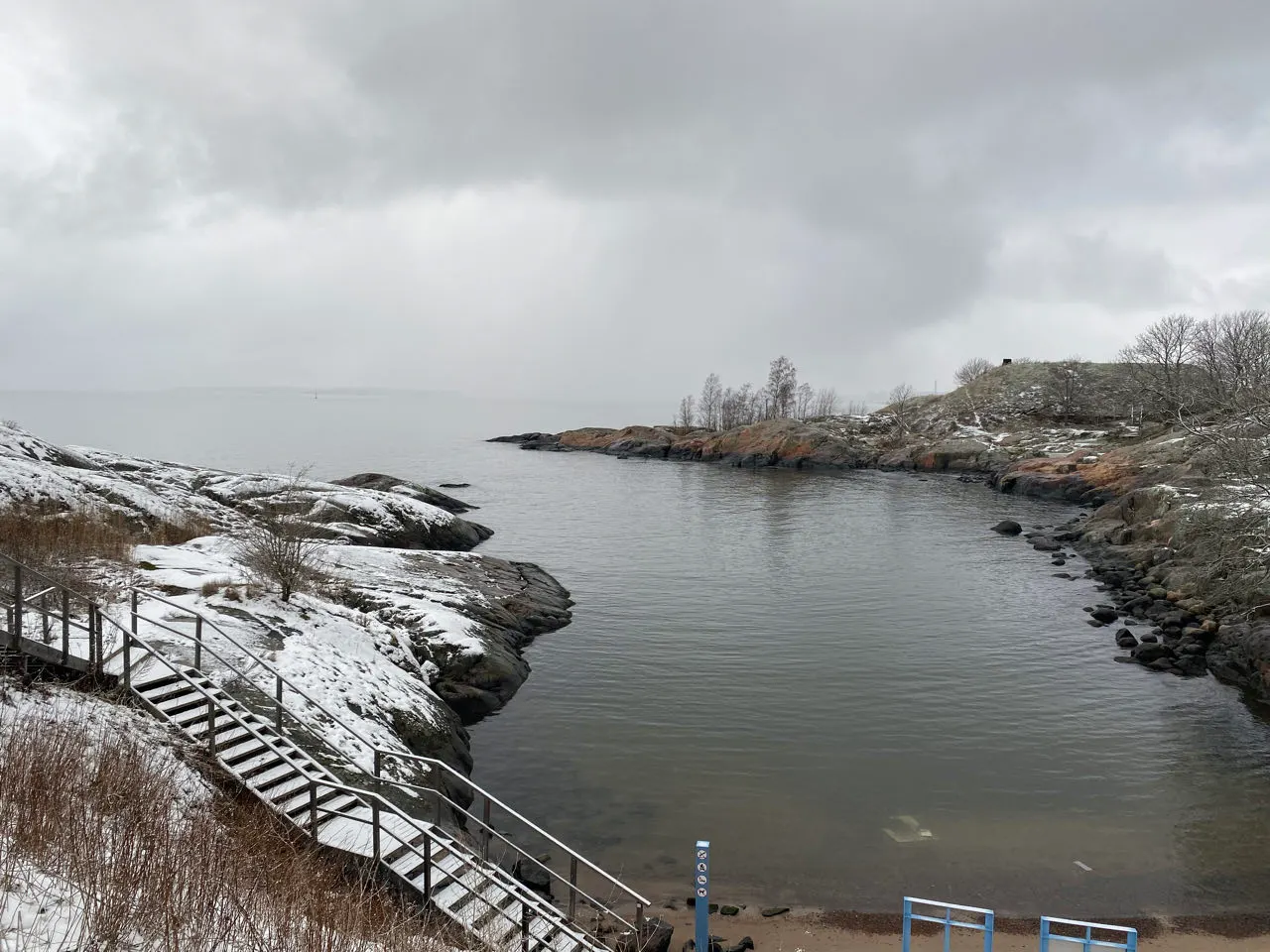 Ruige besneeuwde kustlijn met rotsen en zee op Suomenlinna