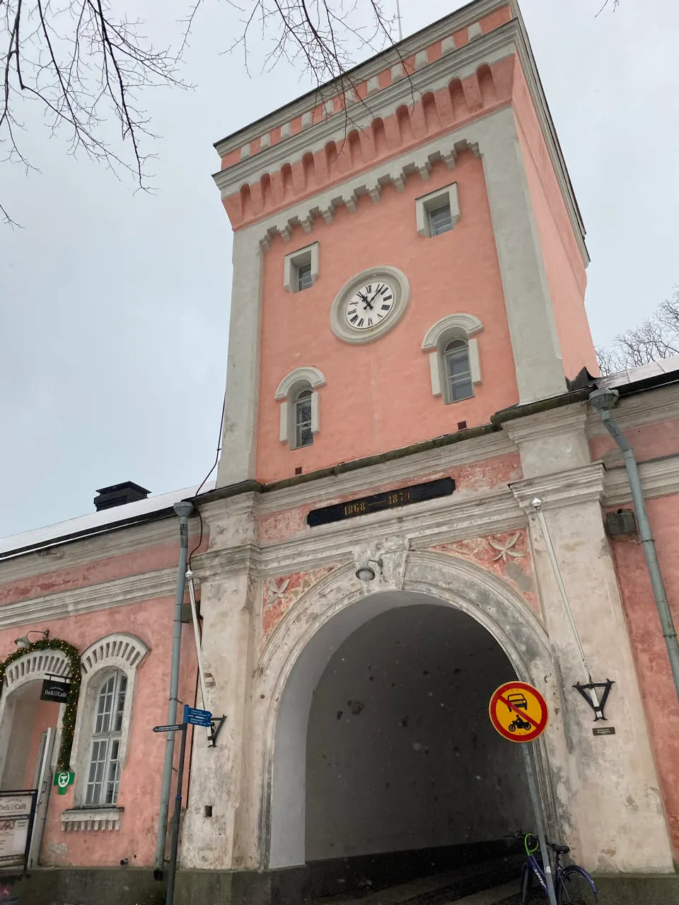 De roze kerktoren en een lang rood gebouw op Suomenlinna in de sneeuw