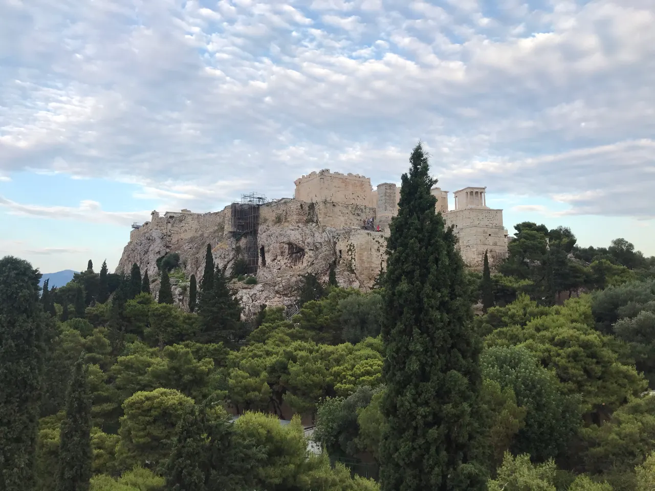 De Akropolis van Athene op de heuvel met cipressen ervoor