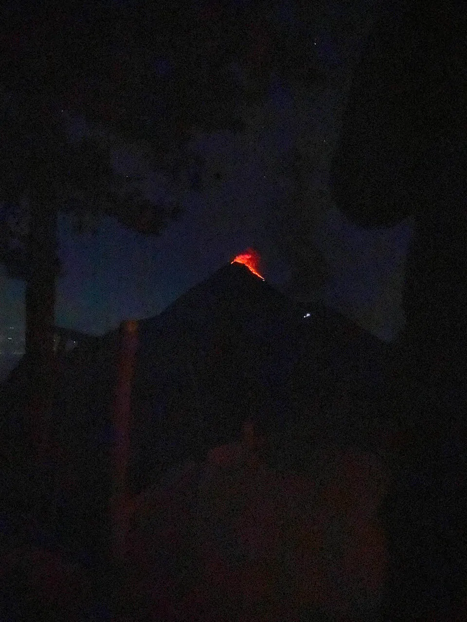 Oranje lava gloeit in het donker op de top van de Volcán Fuego