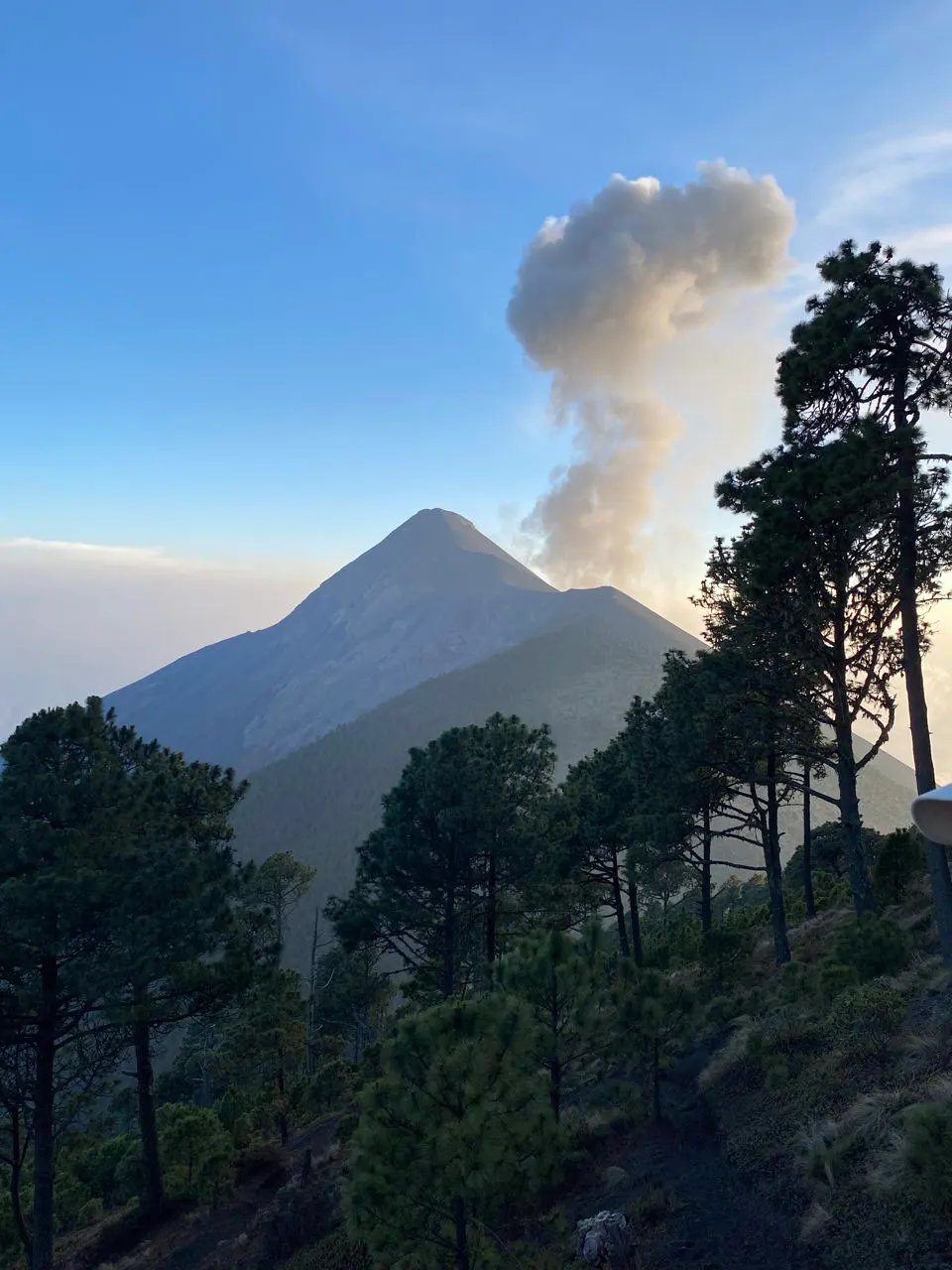 De uitbarstende Volcán Fuego met een aswolk boven de Acatenango bij daglicht