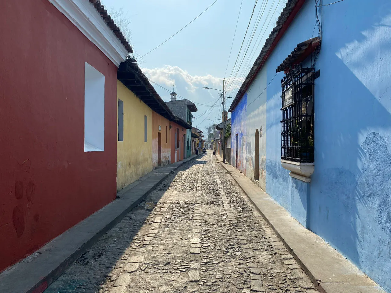 Smalle kasseienstraat met blauwe koloniale muren in Antigua Guatemala