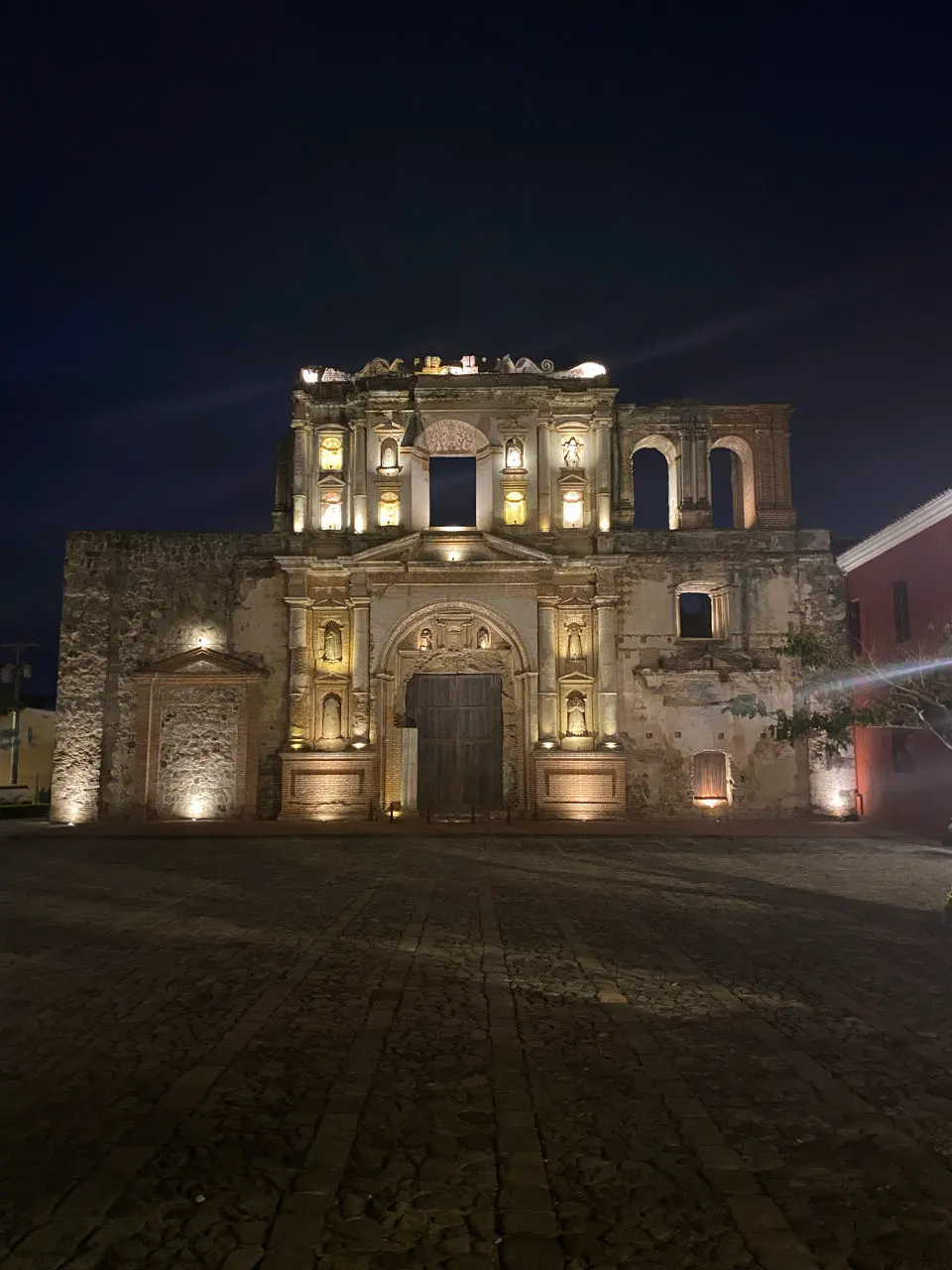Een verlichte kerkgevel in Antigua Guatemala in de avond