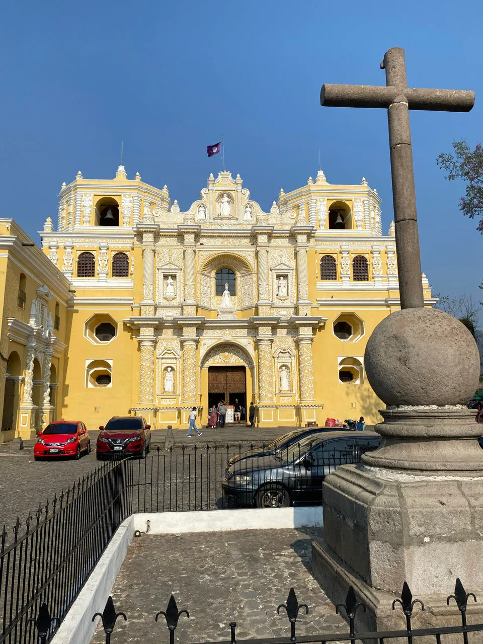 De felgele kerk La Merced in Antigua Guatemala onder een blauwe lucht