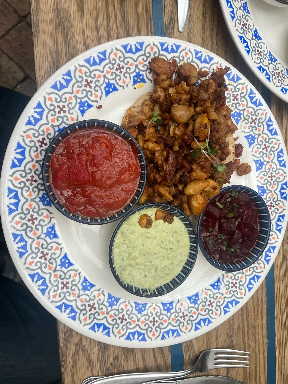 Een Hongaars gerecht met gefrituurd vlees en drie dipsausjes op een bord