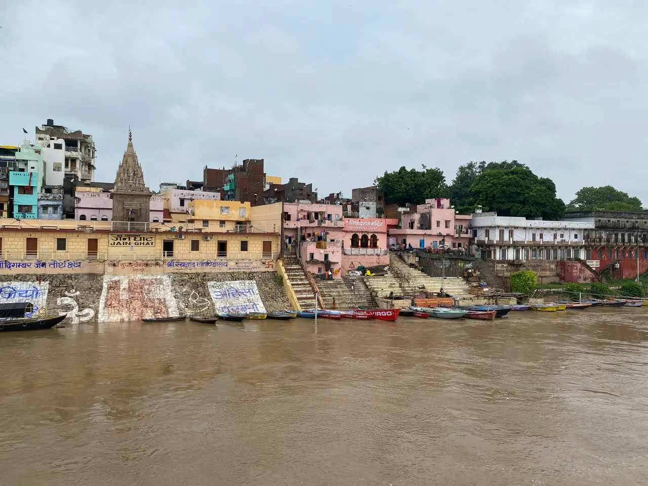 De ghats en gekleurde gebouwen van Varanasi gezien vanaf de rivier