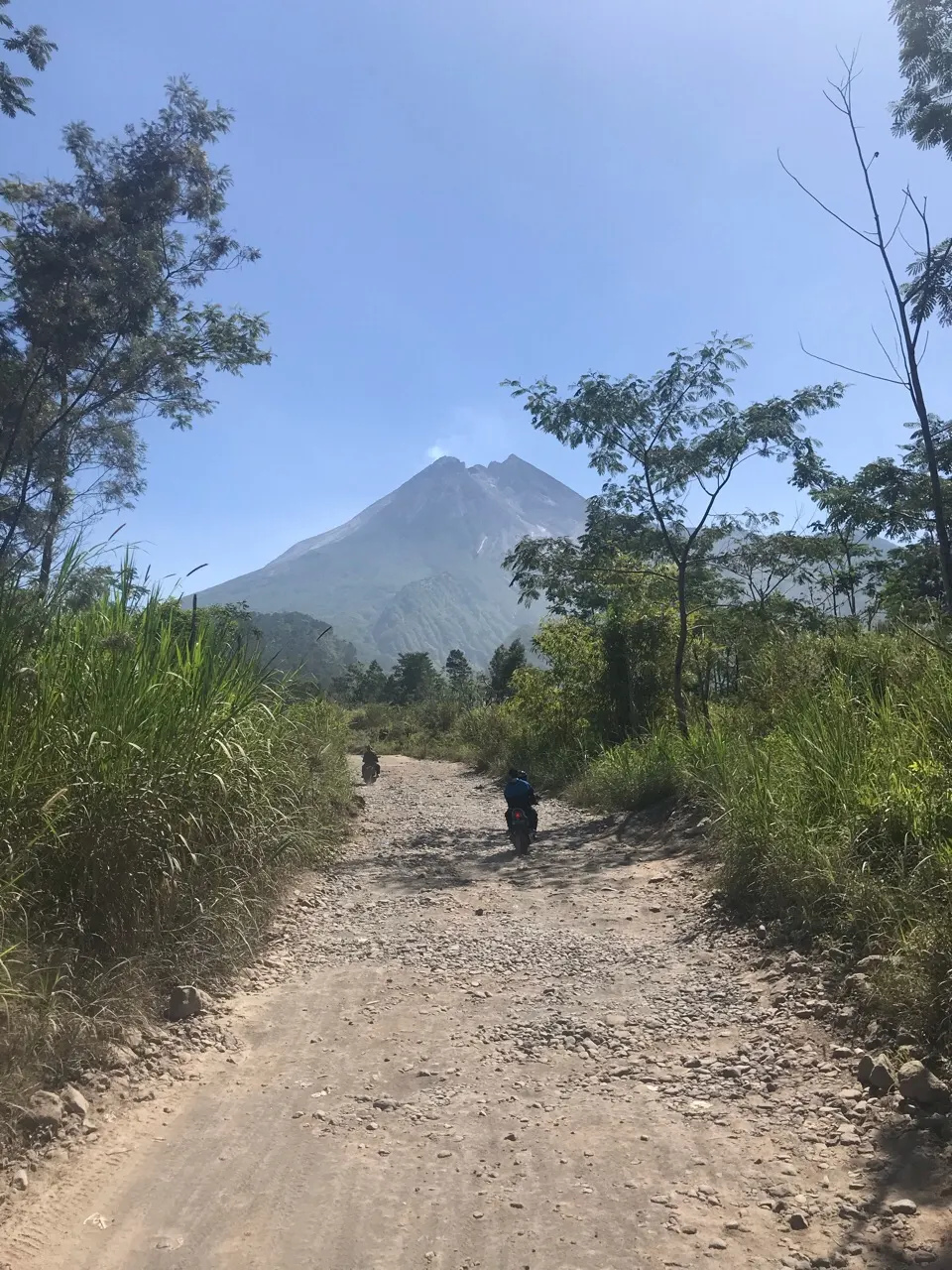 De Merapi vulkaan gezien vanaf een hobbelig zandpad bij Yogyakarta