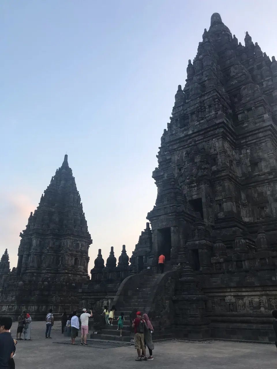 Een hoge gebeeldhouwde tempeltoren van Prambanan tegen een blauwe lucht