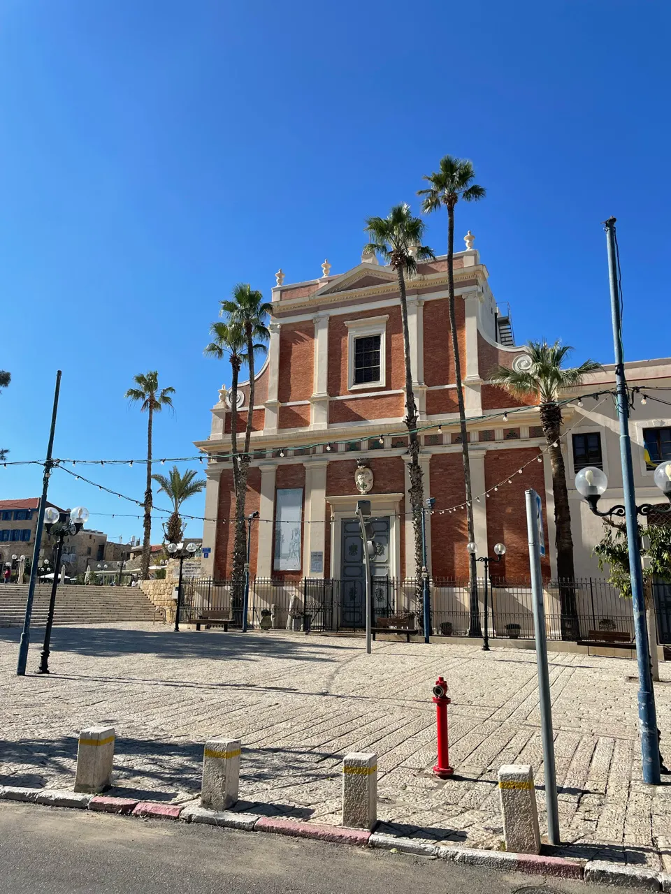 Rood bakstenen gebouw met palmbomen in het oude Jaffa