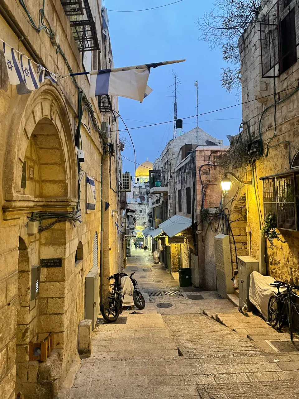 Smal steegje in de oude stad van Jeruzalem met oude gebouwen en warm avondlicht