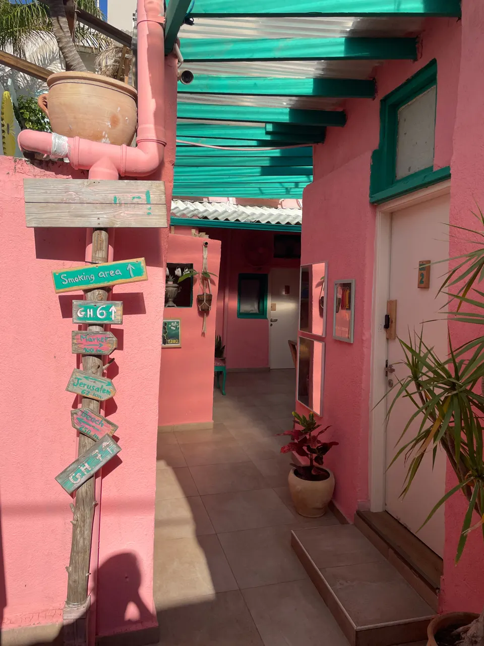Kleurrijk roze en groen geschilderd gebouw in een straat in Tel Aviv