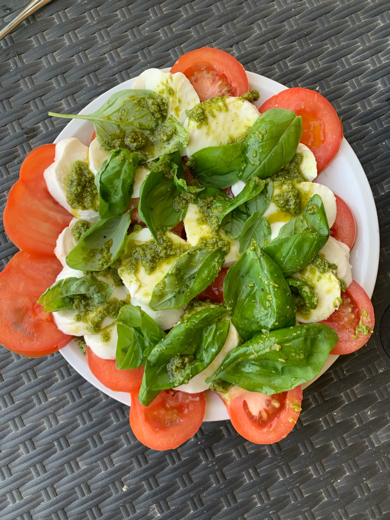 Een caprese salade met tomaat, mozzarella en basilicum