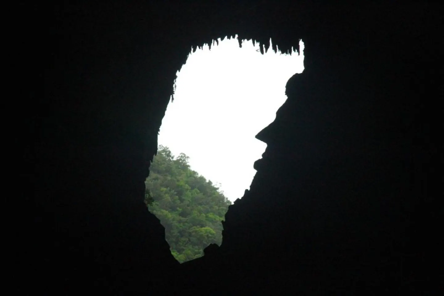 Silhouet van een grotopening met daglicht dat door de rotswand naar binnen valt