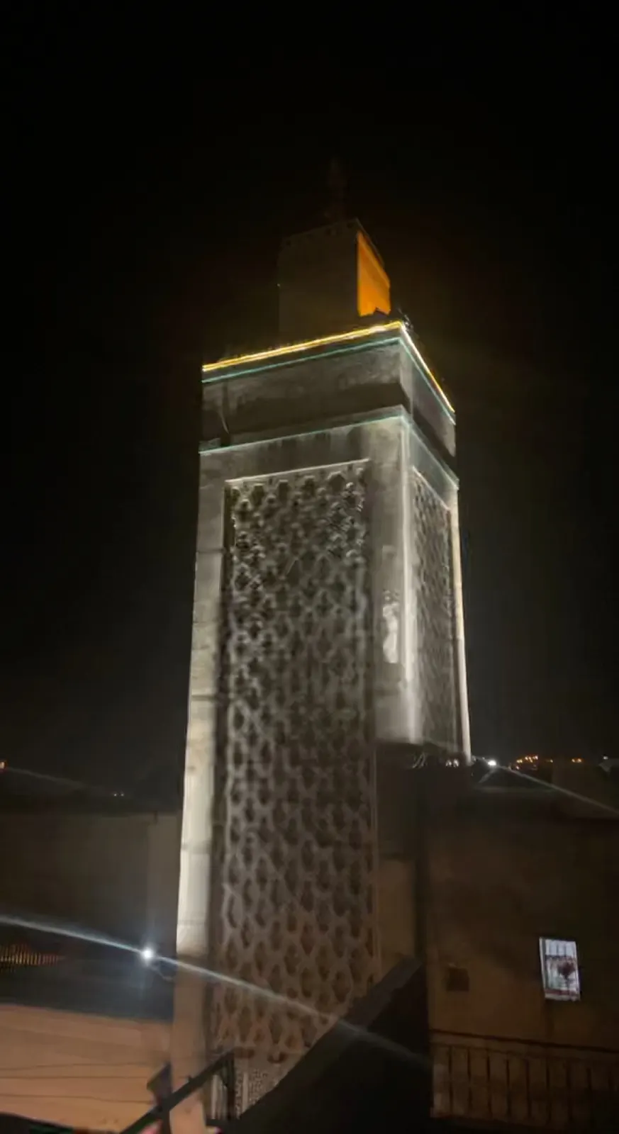 Een verlichte minaret in Fes in de avond