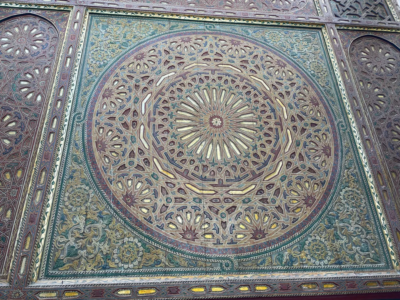 Detail van een rijk versierd houten en stucwerk plafond in Fes
