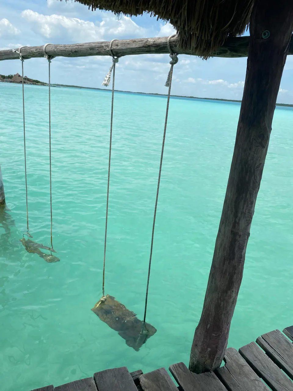 Houten schommel in de lagune van Bacalar, Mexico