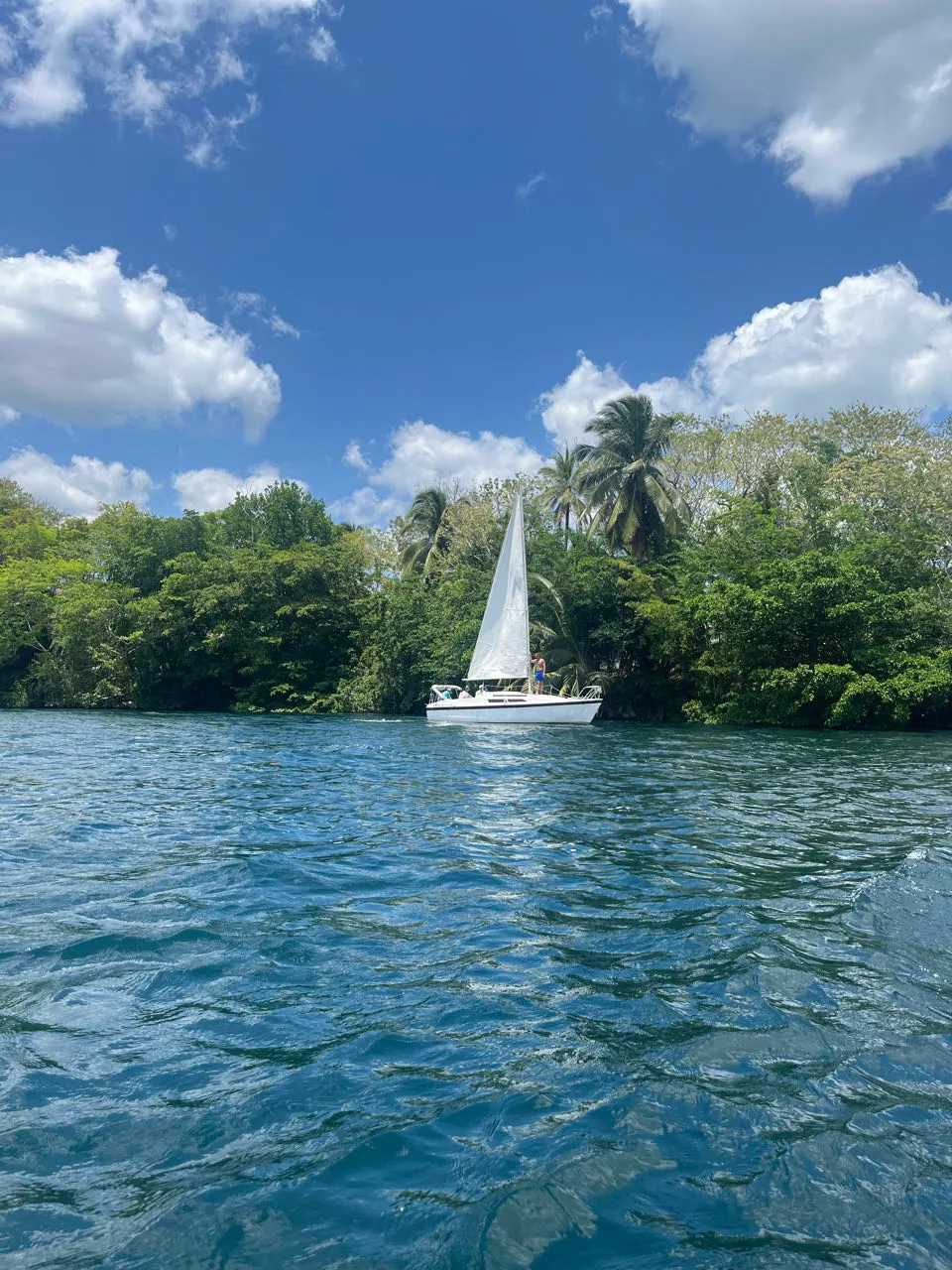 Zeilboot op de rustige lagune van Bacalar onder een blauwe lucht