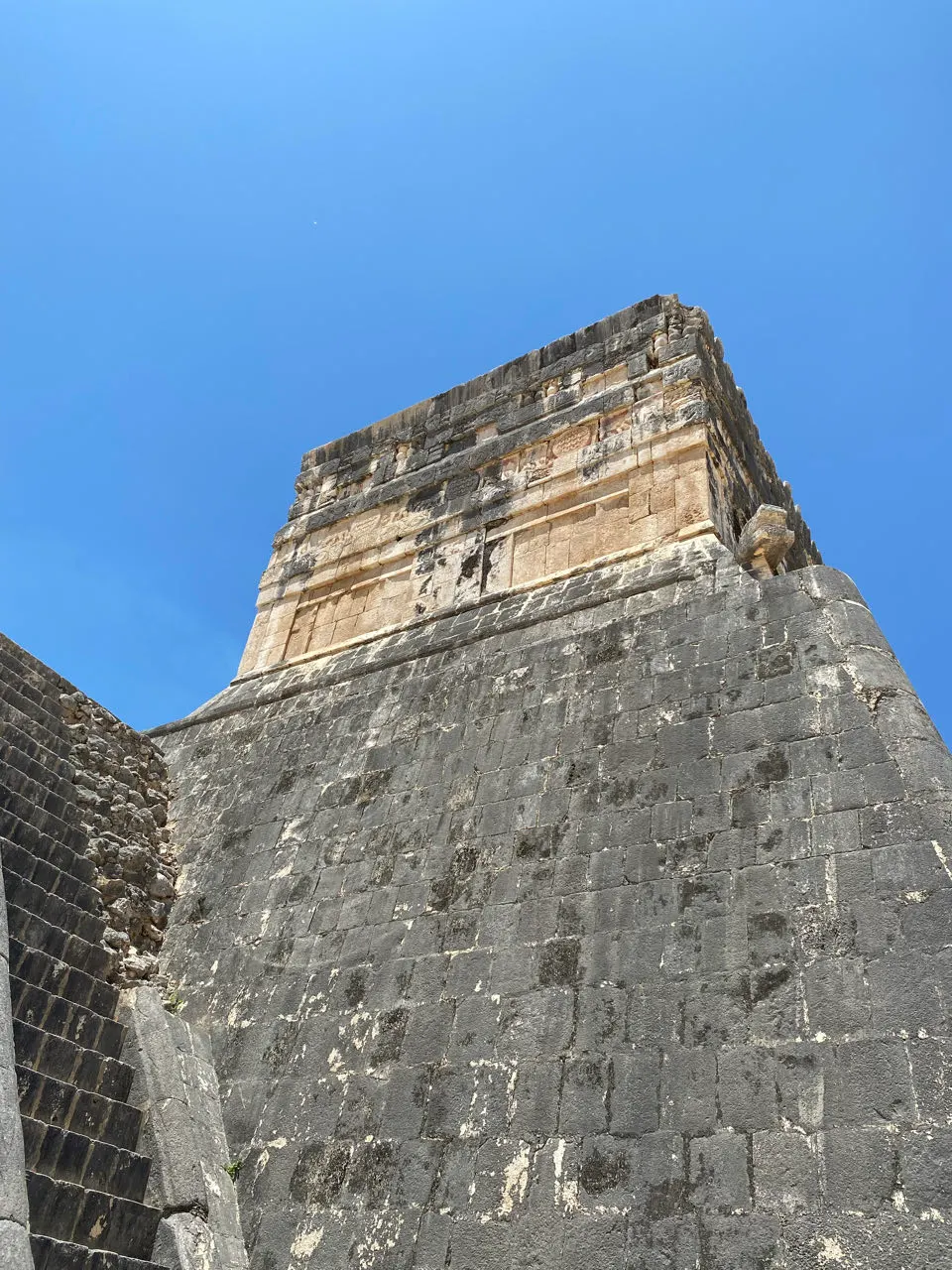 Beeldhouwwerk van een gevederde slangenkop aan de voet van de piramide