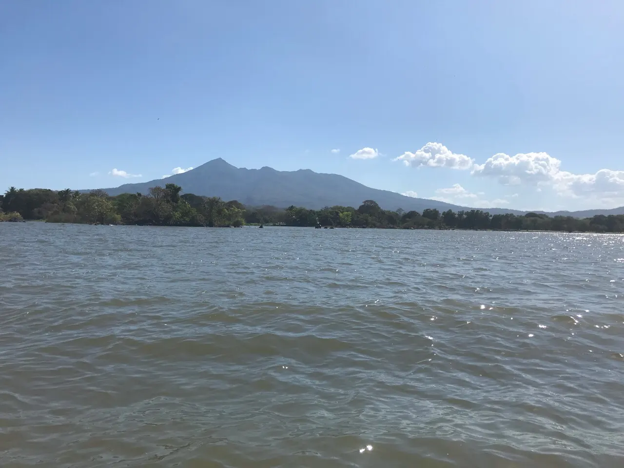 Uitzicht over het Lago Cocibolca vanaf een boot met een vulkaan in de verte