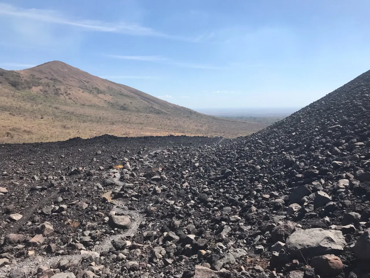 De kale zwarte helling van de Cerro Negro vulkaan tegen een blauwe lucht