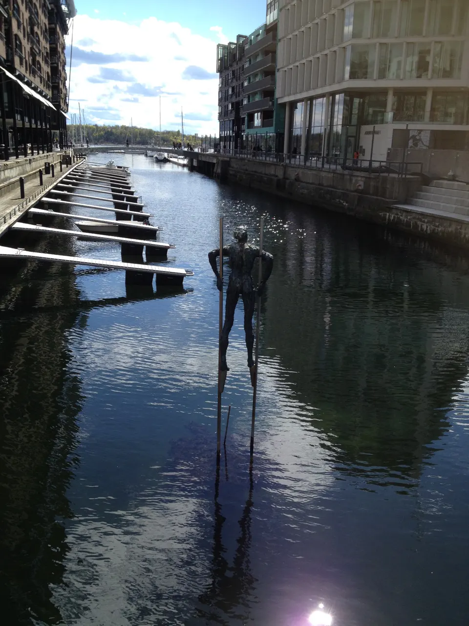 Kanaal bij Aker Brygge in Oslo met moderne gebouwen en beelden in het water