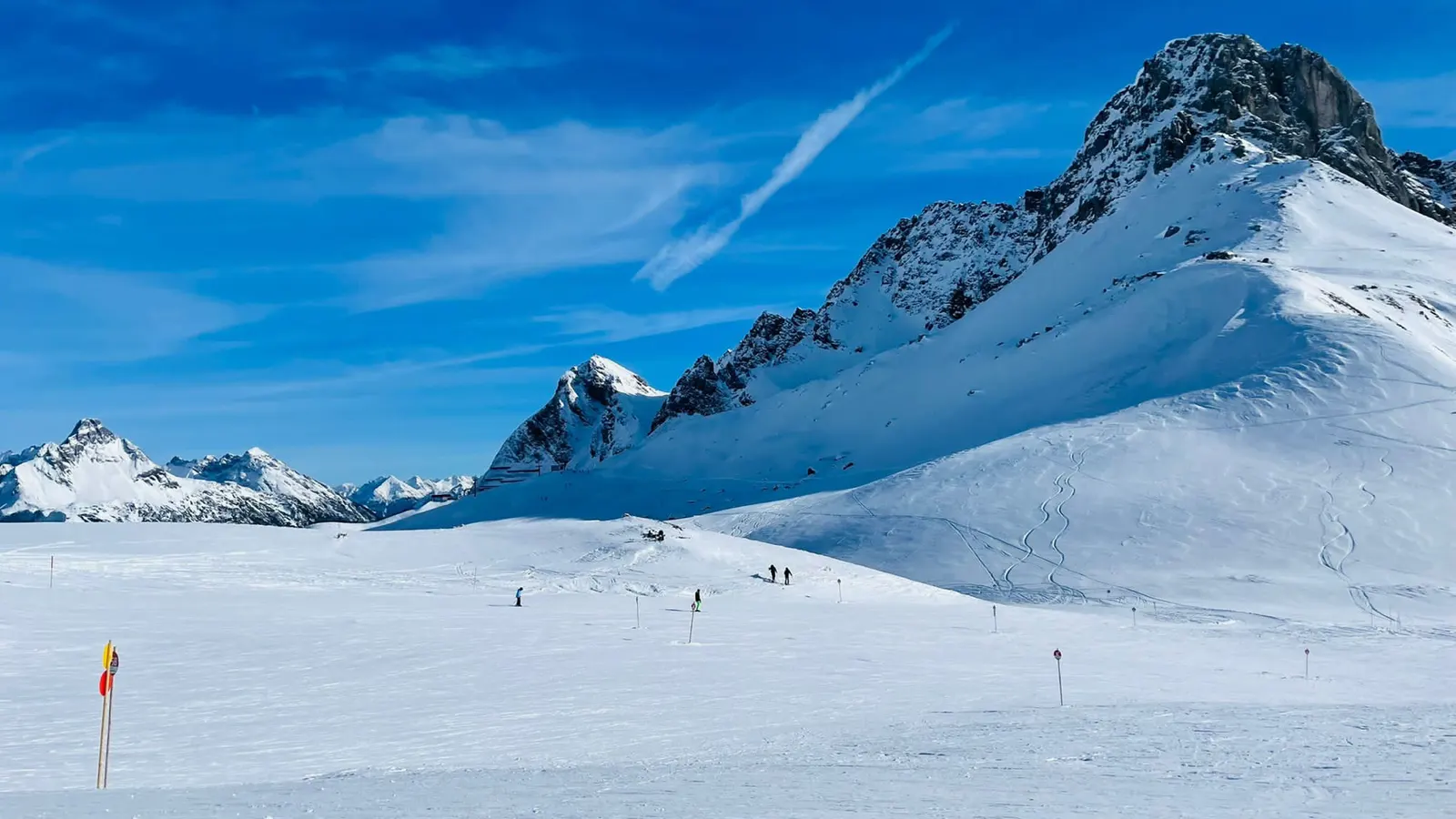 Brede besneeuwde piste aan de Arlberg onder een strakblauwe lucht