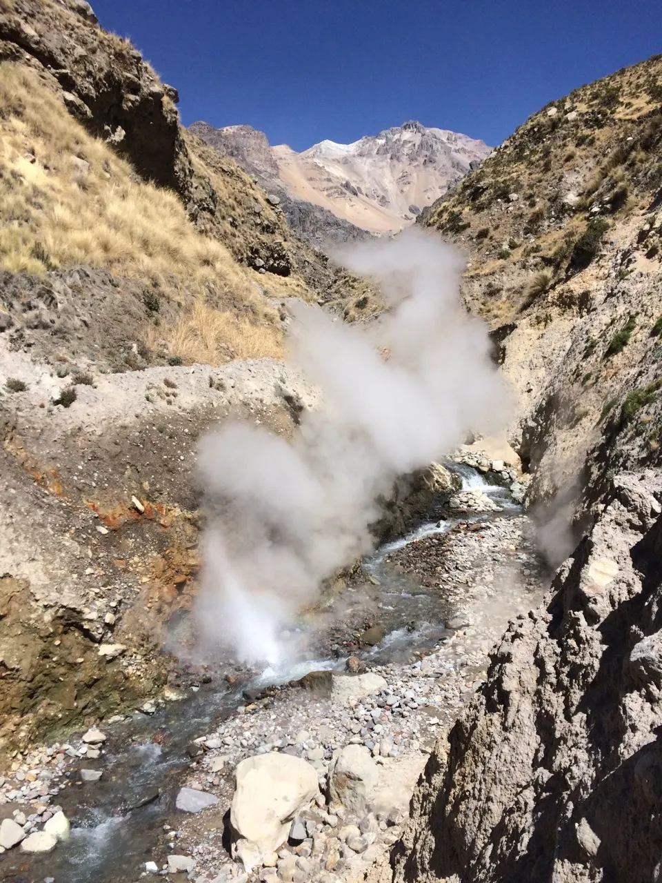 Stoom stijgt op uit een hete bron in de Colca-vallei