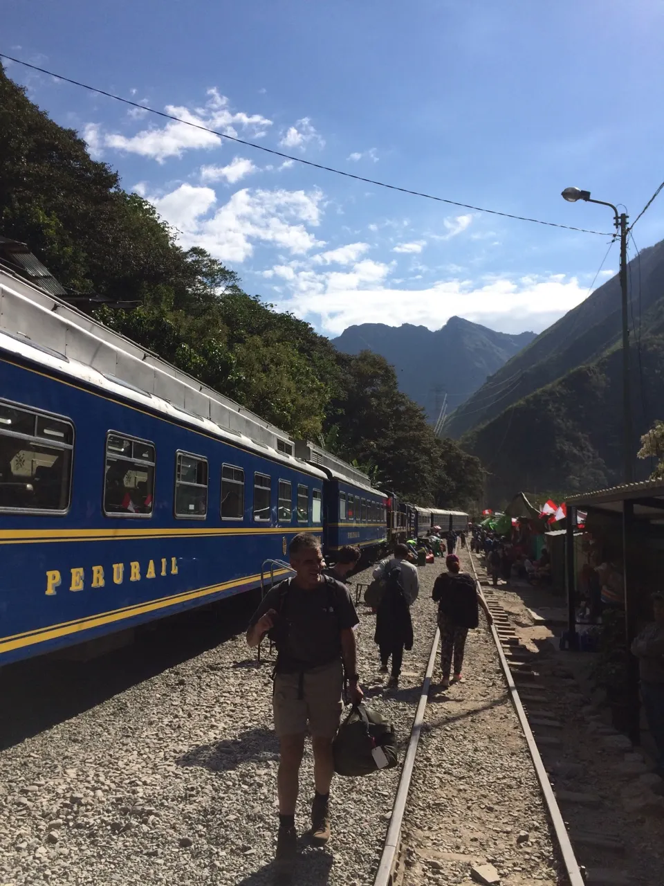 Een blauwe PeruRail-trein op het spoor richting Aguas Calientes