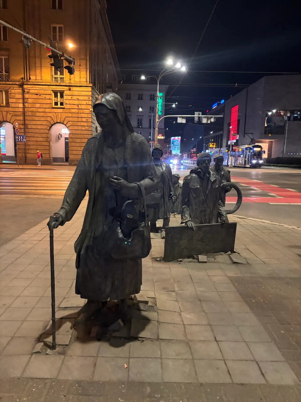 Een bronzen standbeeld in een straat van Wroclaw in de avond