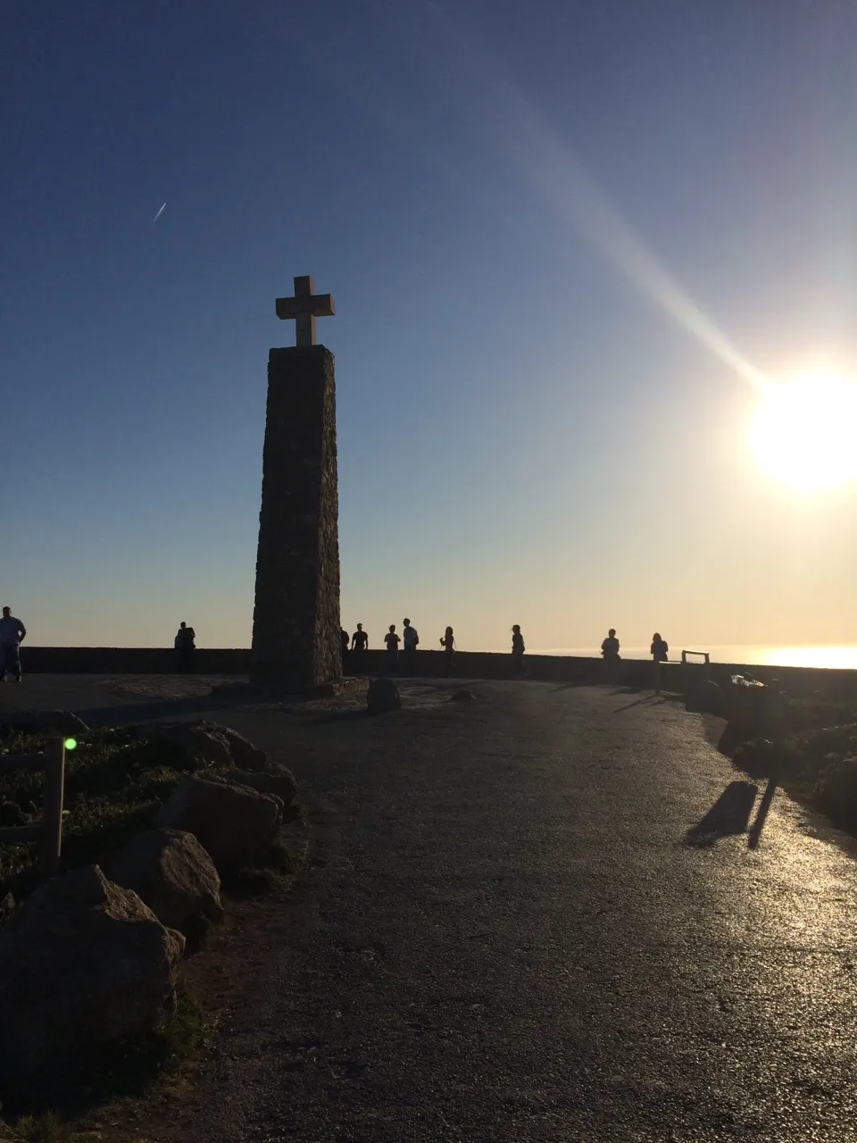 Silhouet van het kruismonument bij Cabo da Roca terwijl de zon boven de oceaan ondergaat