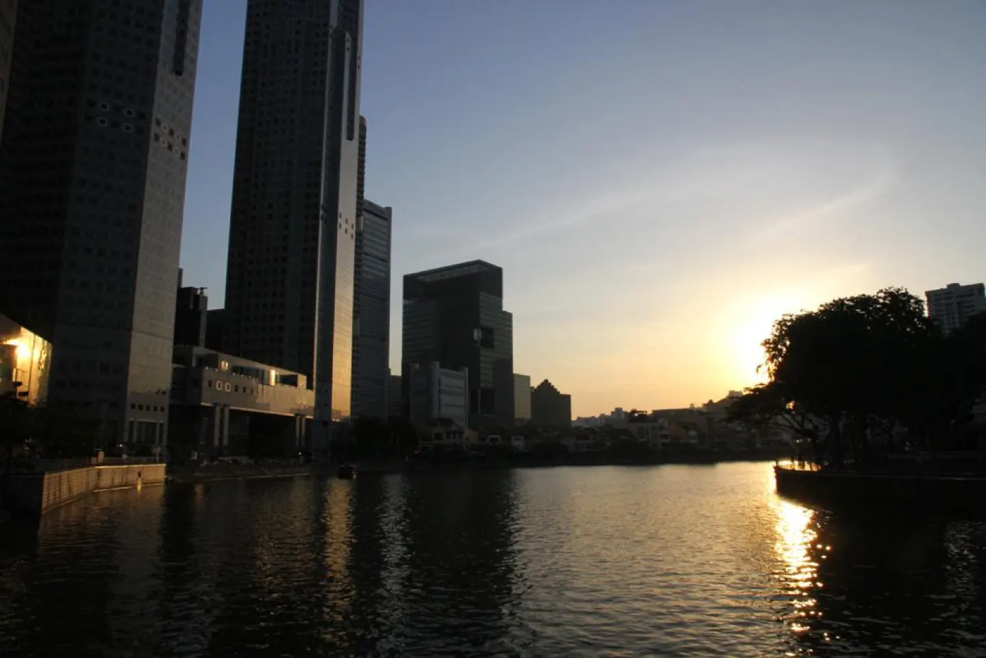 De Singapore River bij zonsondergang met wolkenkrabbers op de achtergrond