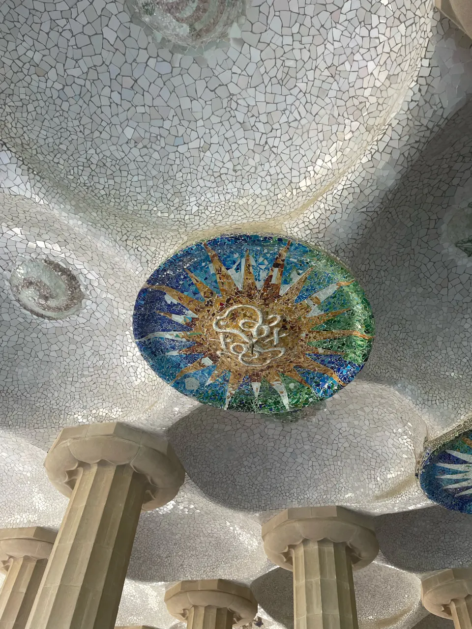 Een kleurrijk mozaïek van gebroken tegels in het plafond van Park Güell