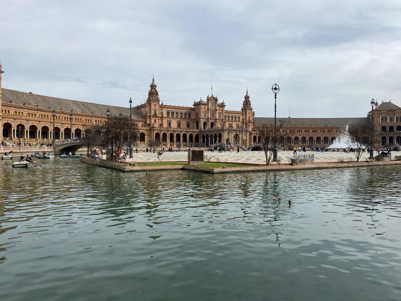 Het Plaza de España in Sevilla gezien vanaf het water met bootjes en de gele gebouwen