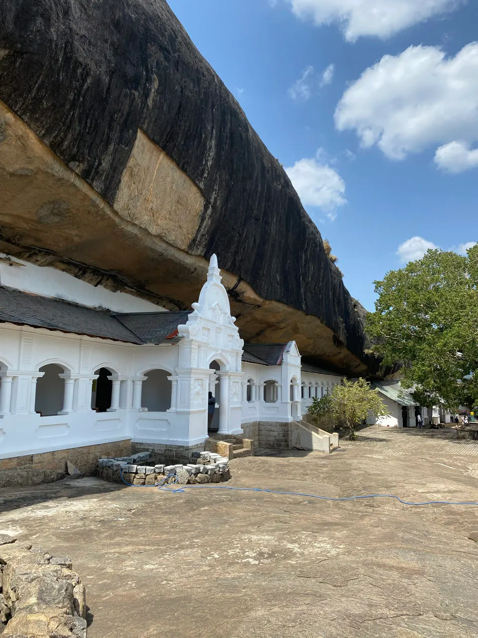 De witte gevel van de Dambulla-grottempel onder de overhangende rots