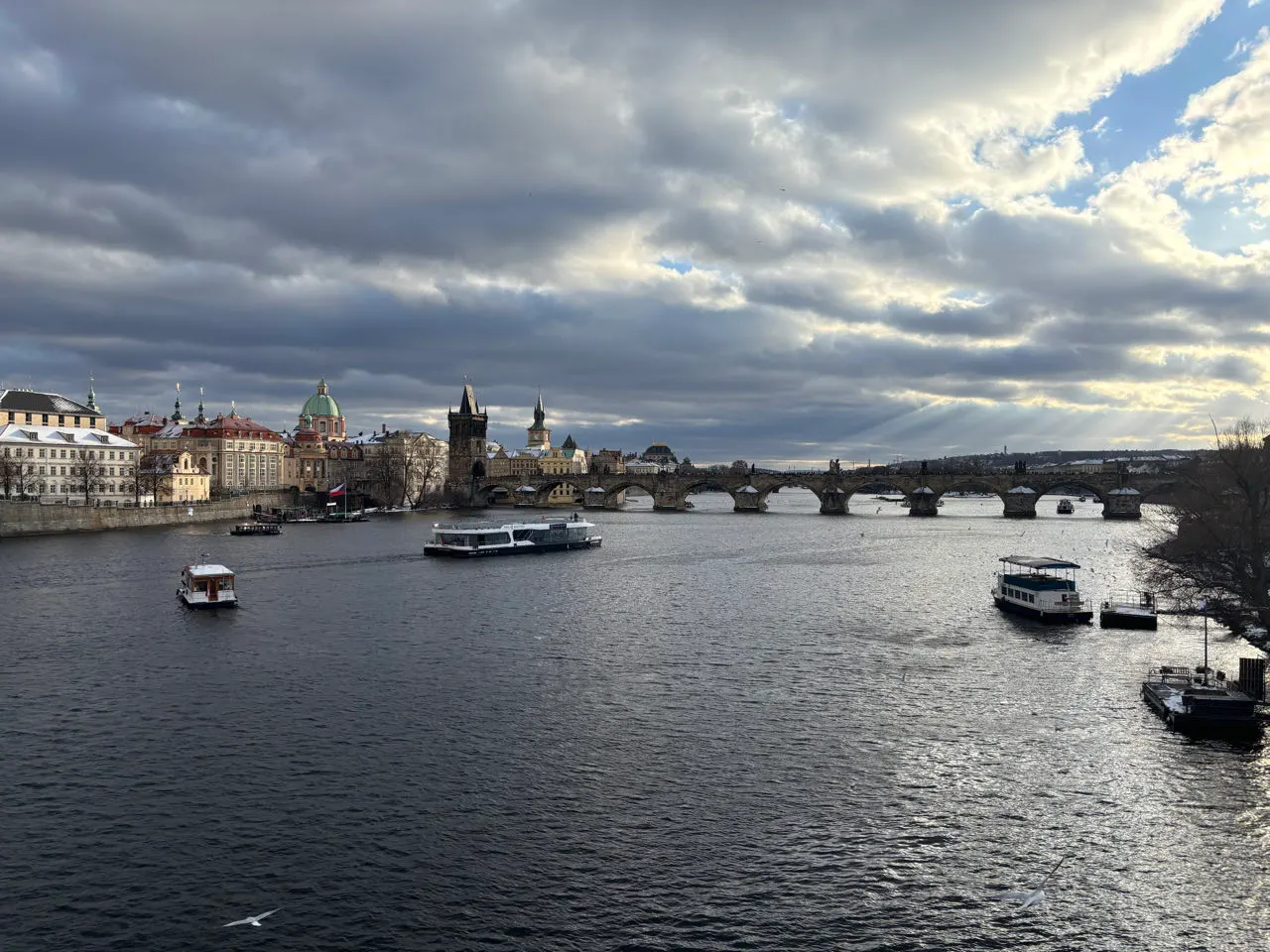 De Moldau met de Karelsbrug en de daken van Praag onder een winterlucht